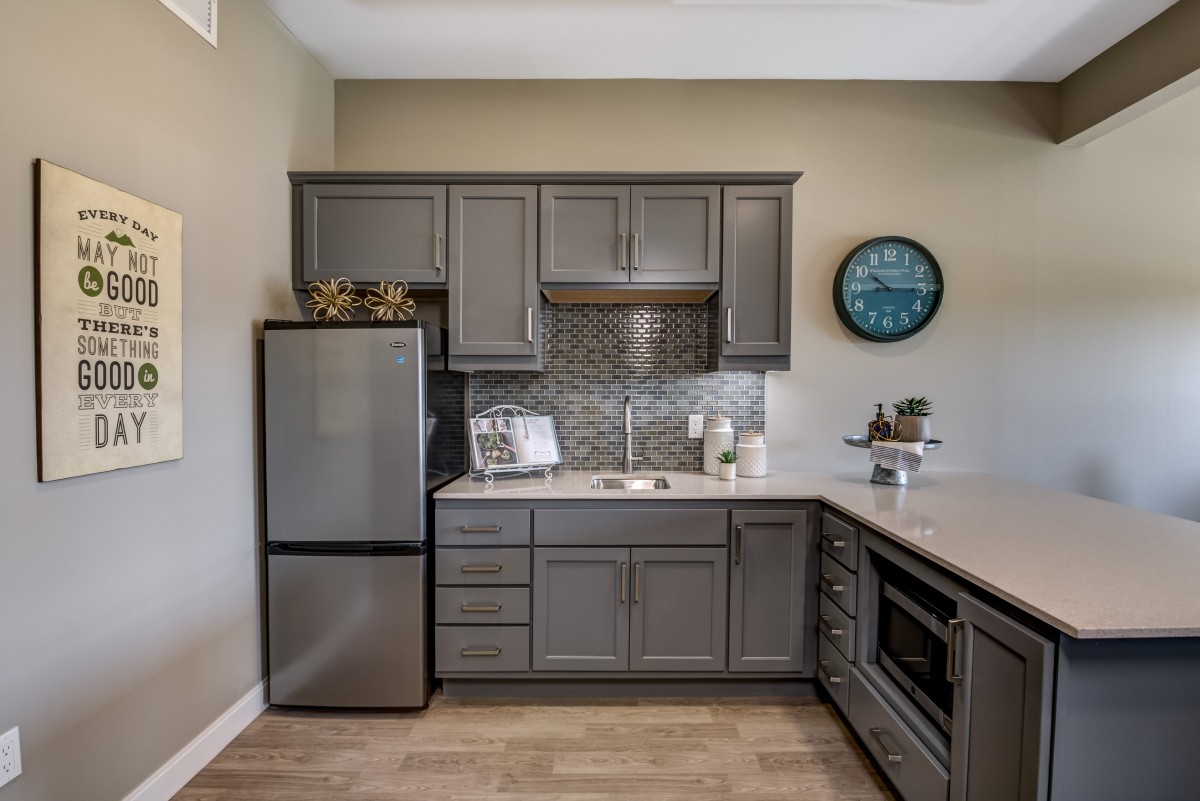 A modern kitchen with sleek gray cabinets and stainless steel appliances.