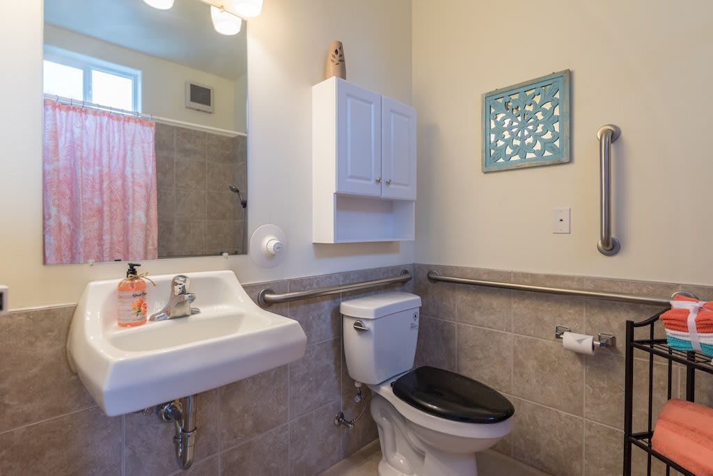 A clean and simple bathroom with a sink, toilet, and wall-mounted storage.