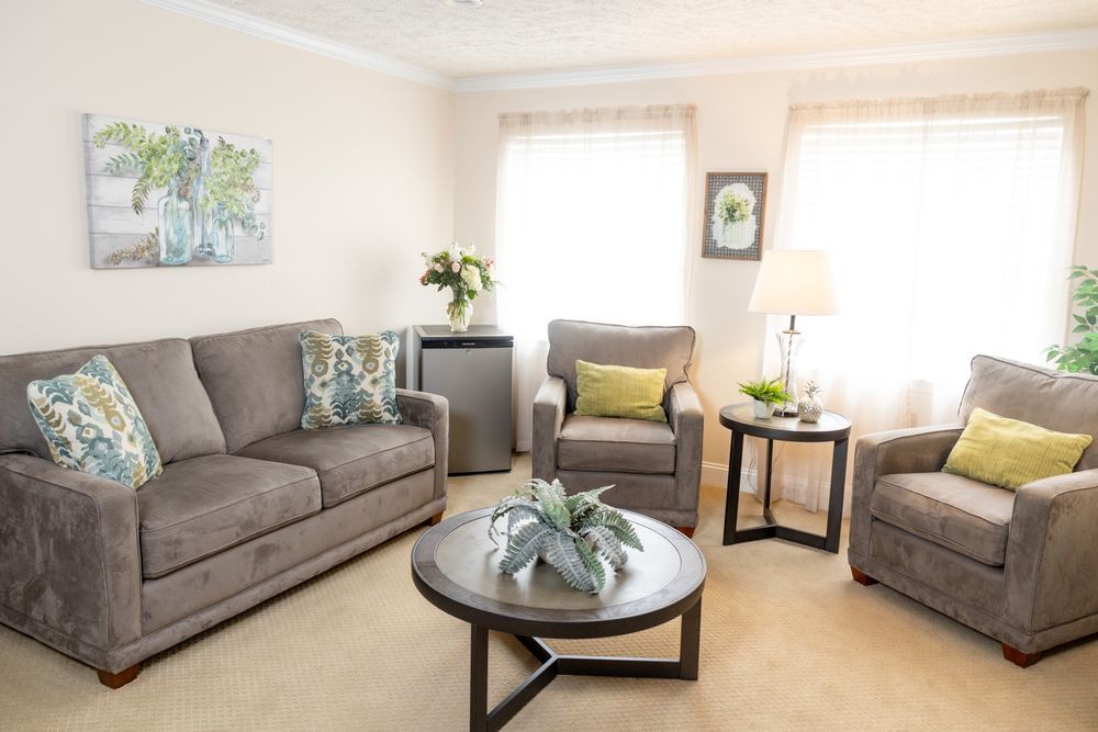 A cozy living room with a sofa, armchair, coffee table, and tasteful decor.