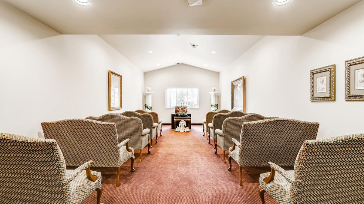 A serene chapel with rows of comfortable chairs arranged for a ceremony.