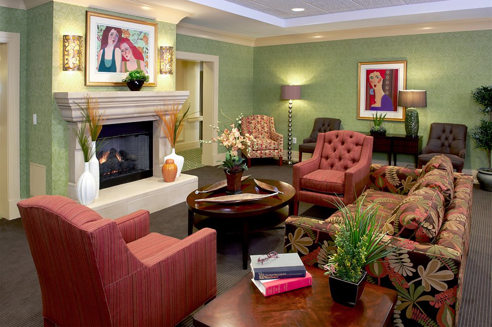 A cozy and stylish living room featuring comfortable seating, a fireplace, and decorative artwork.