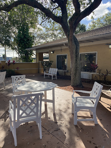 A serene outdoor patio area with white furniture and natural surroundings.