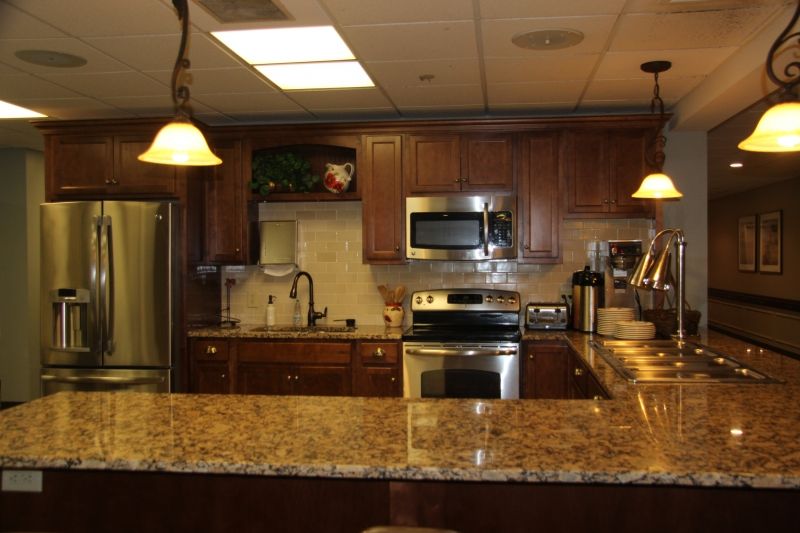 A modern kitchen with granite countertops and wooden cabinets.