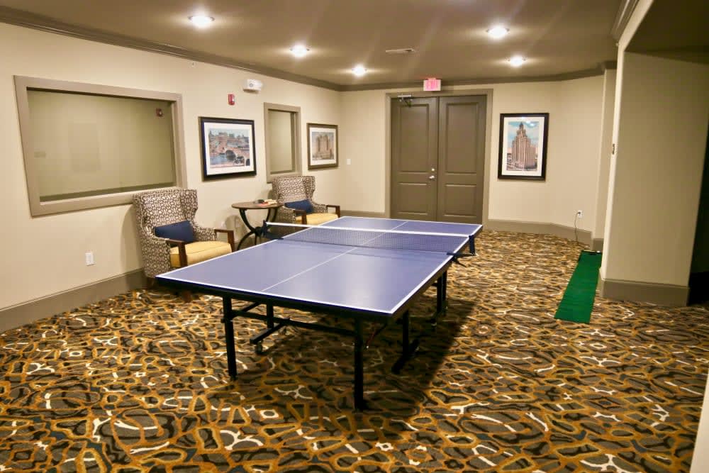 A cozy recreation room featuring a ping pong table and framed artwork on the walls.