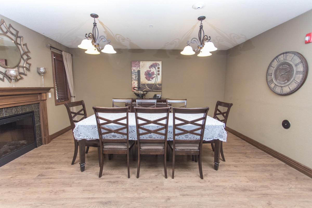 A well-lit dining room with a set table and chairs.
