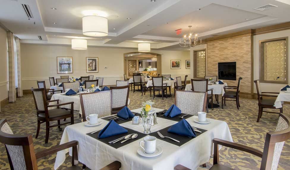 An elegantly set dining area with neatly arranged tables and chairs, showcasing a sophisticated interior design.