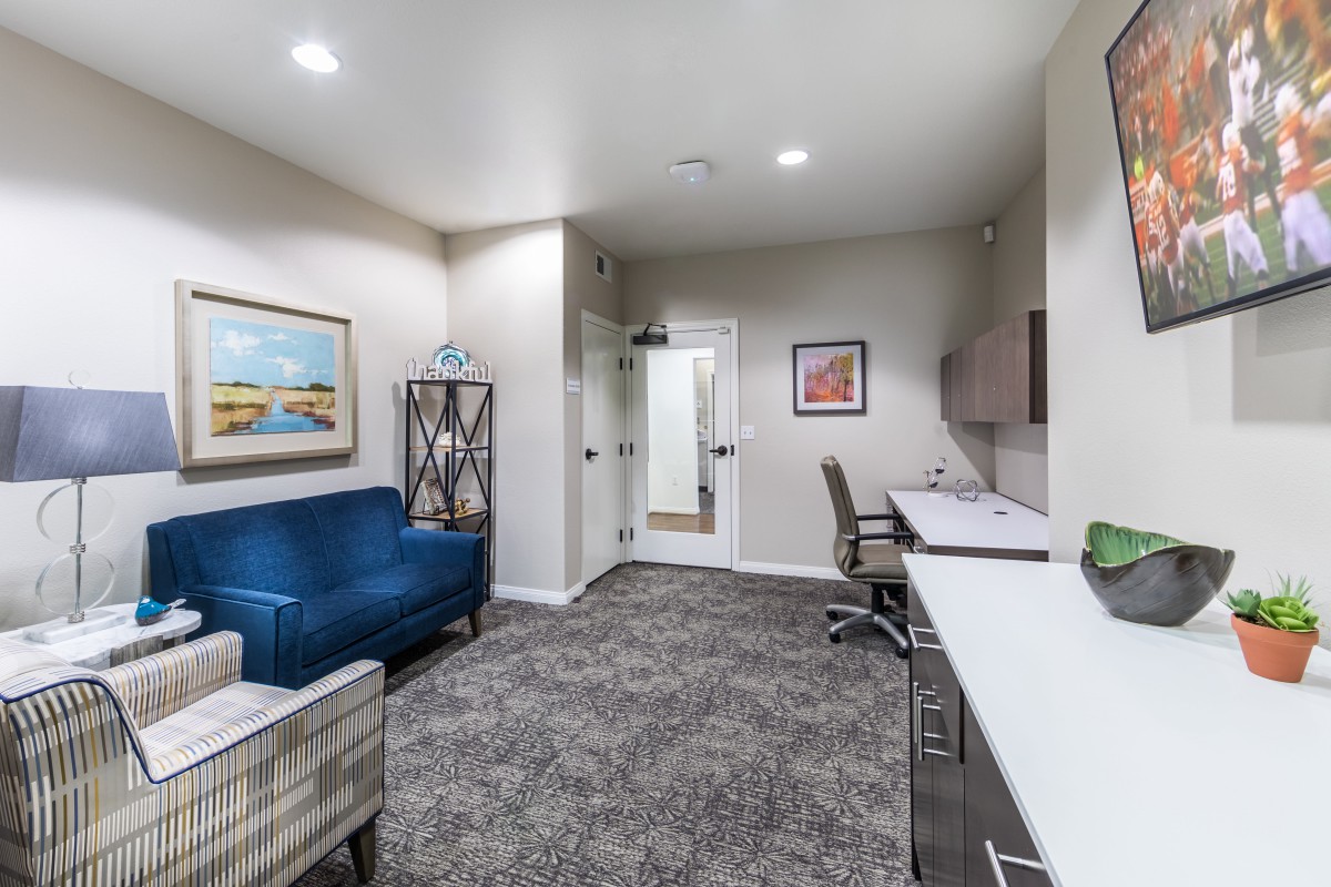 A modern office space featuring a blue sofa, desk, and stylish decor.