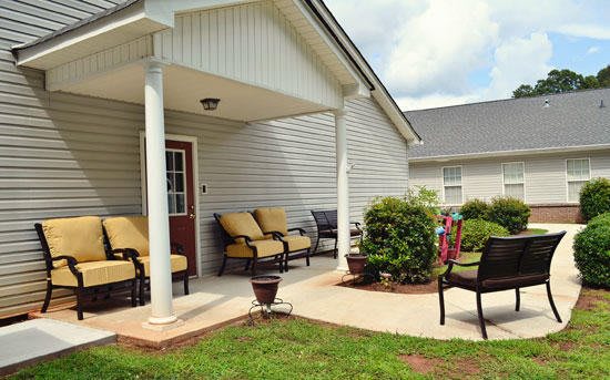 A cozy patio with comfortable outdoor seating and lush plants.