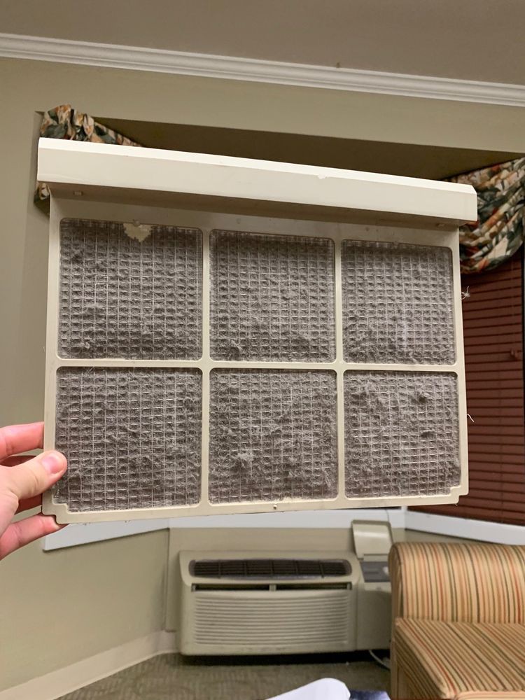 A dirty air filter from an indoor appliance, needing cleaning or replacement.