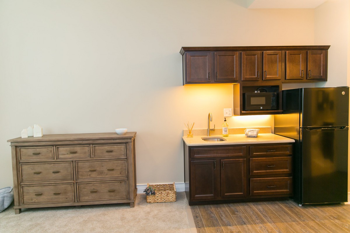 A kitchen interior with wooden cabinets and a countertop featuring a sink.