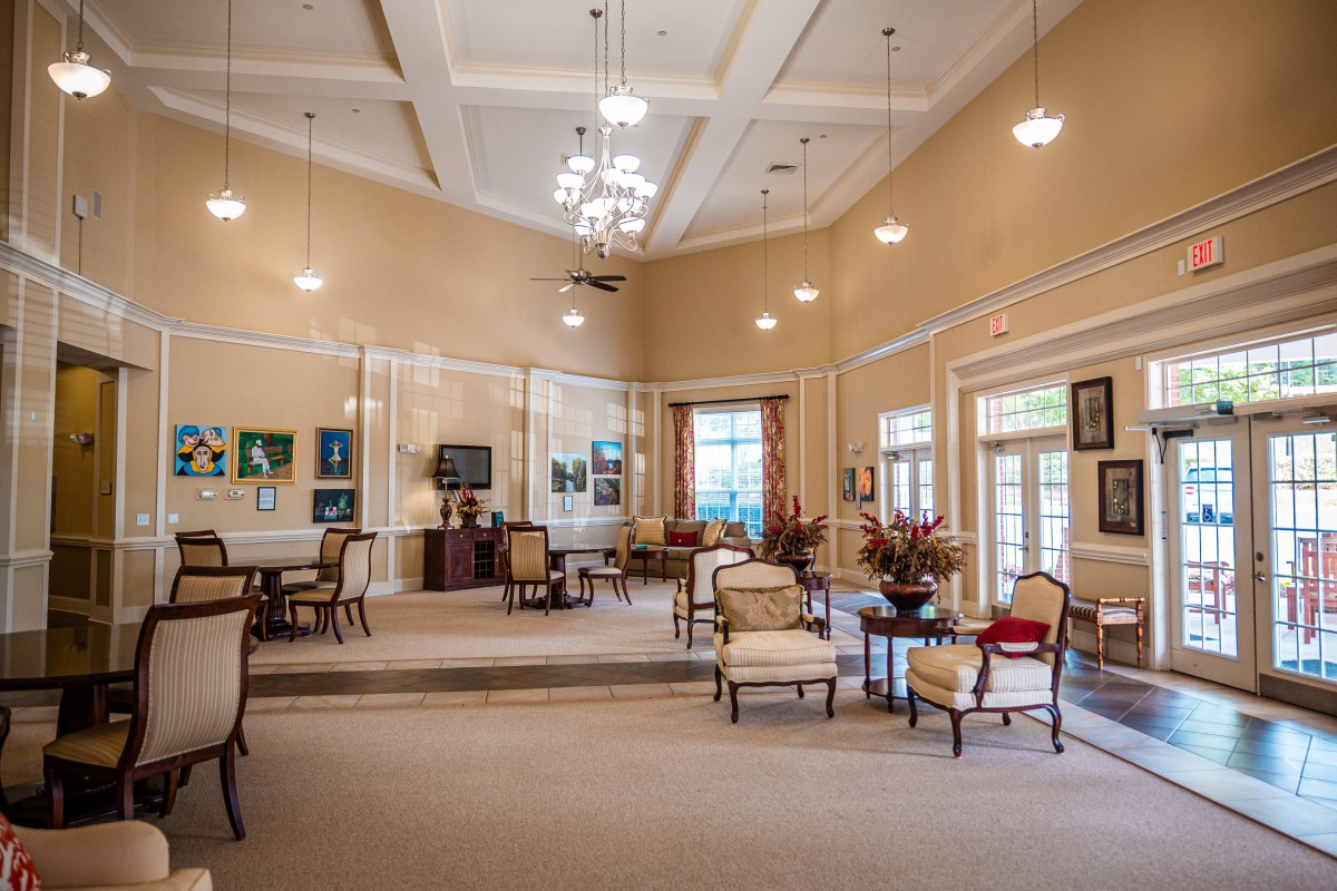 Spacious lobby area with comfortable seating, chandeliers, and large windows.