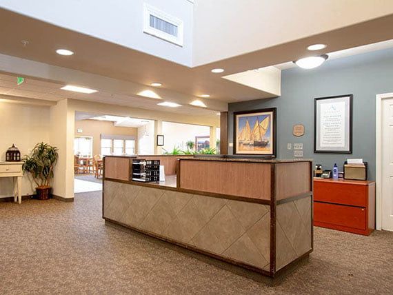 A modern office reception area with a central desk and bright lighting.