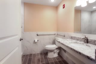 A modern bathroom with a toilet and marble countertop.