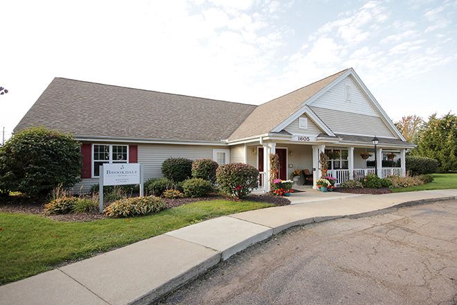 A suburban house with a landscaped entrance and sidewalk.