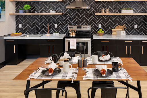 A modern kitchen and dining area featuring a chic black and white color scheme with a stylish table setting.