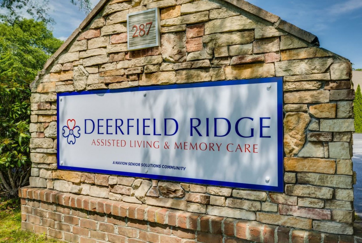 Sign for Deerfield Ridge Assisted Living & Memory Care on a brick wall.