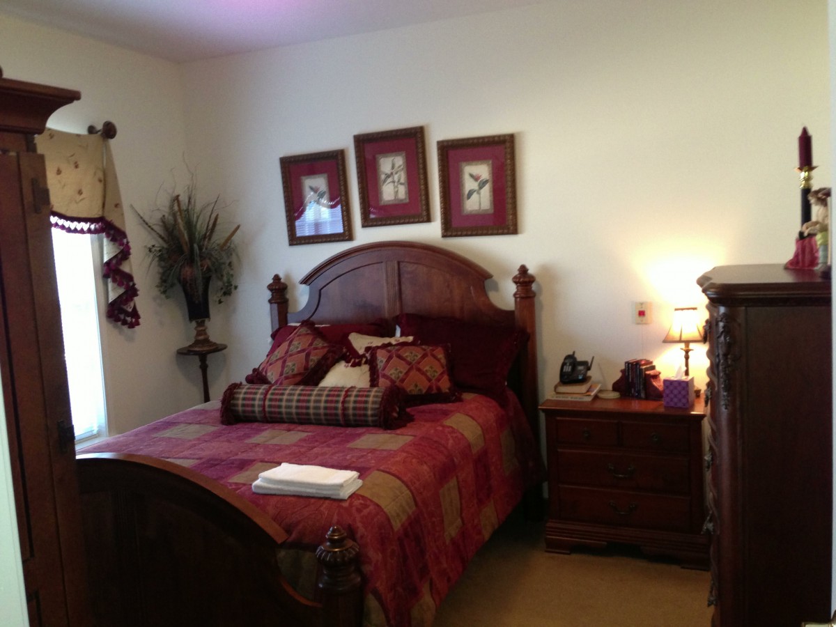A cozy, traditionally decorated bedroom with a wooden bed and elegant furnishings.