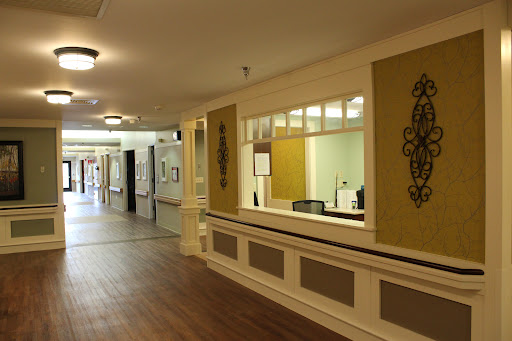 A view of a spacious hallway featuring a reception area with natural lighting.
