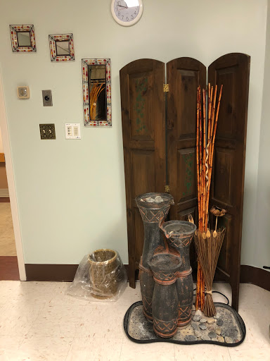 A cozy corner showcasing a wooden screen and decorative vases with bamboo sticks.