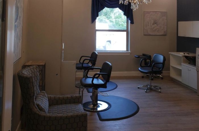 Interior of a hair salon with styling chairs and a large window.
