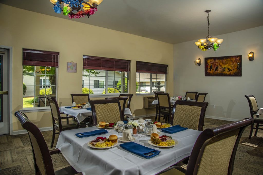 A cozy dining area with elegantly set tables and comfortable seating.