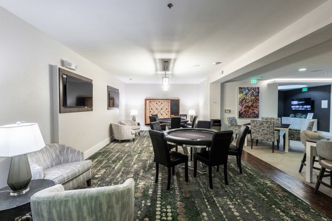 A modern lounge area with comfortable seating, tables, and a television.