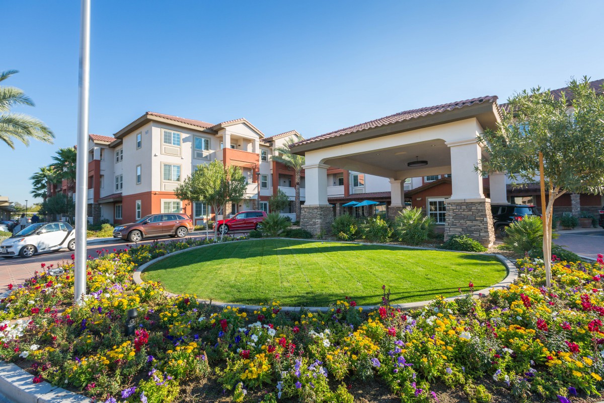 A modern residential building with well-maintained landscaping and vibrant greenery.