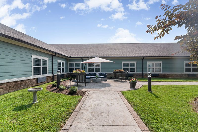 A residential building with a well-maintained courtyard featuring outdoor furniture and landscaping.