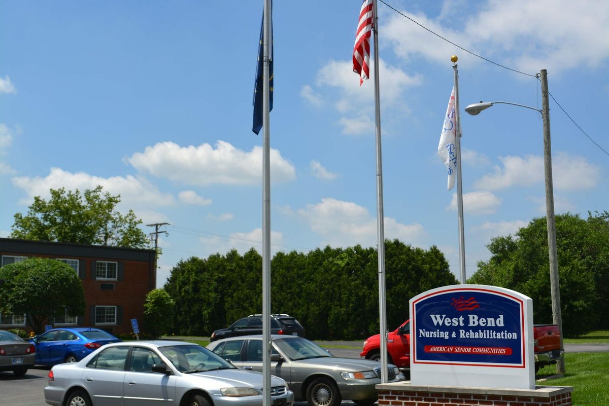 A car dealership with flags and parked cars.