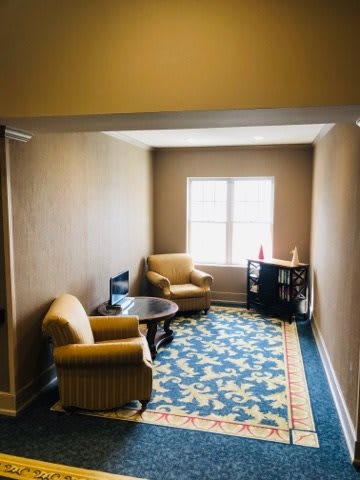 A cozy seating area with two armchairs and a table by the window.