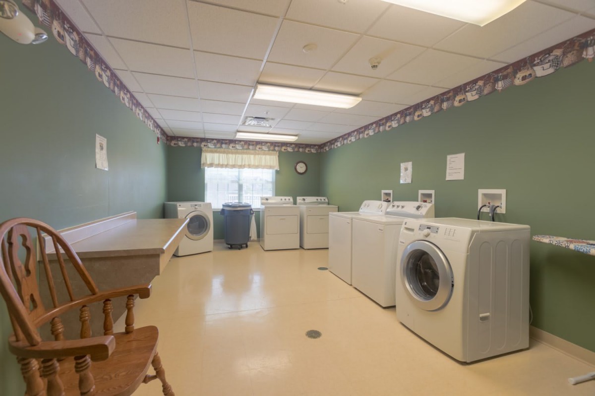A spacious laundry room with multiple washing machines and dryers.