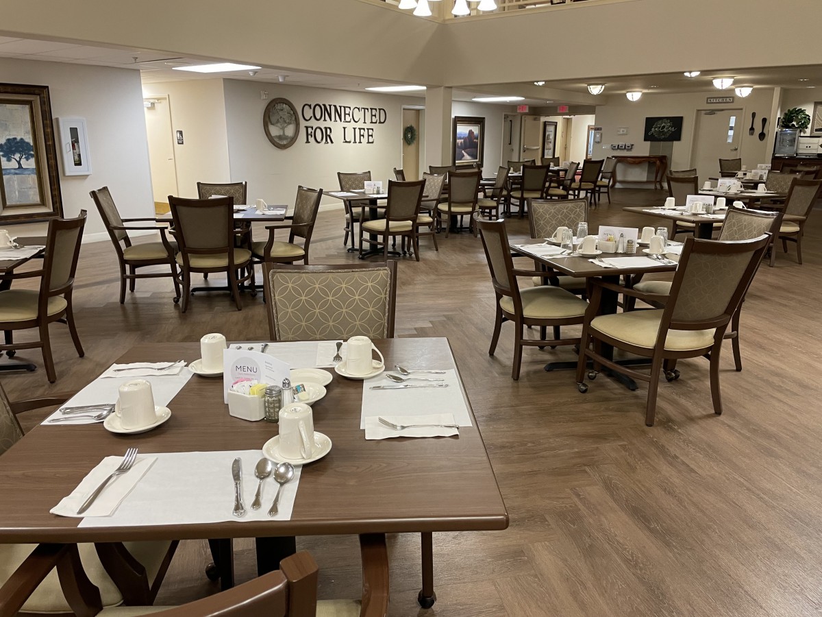 A well-arranged dining area with neatly set tables and chairs, ready for guests.