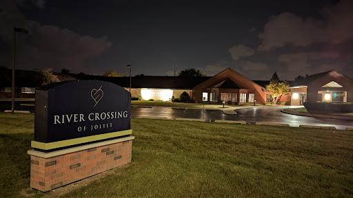 A nighttime view of a building with a prominent sign in front.