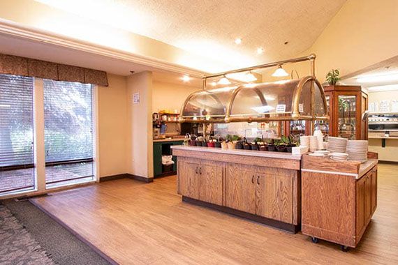 A cozy buffet-style dining area with a food display and warm lighting.