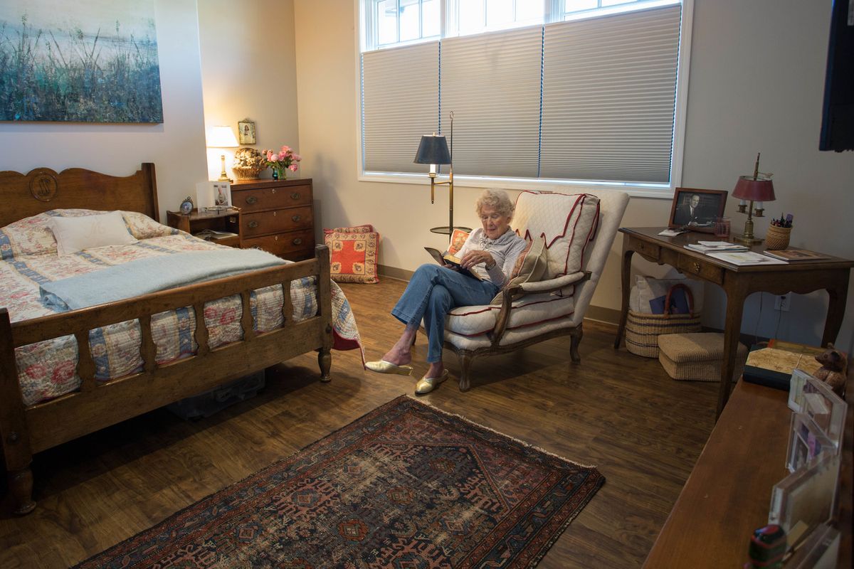 A person reading a book in a cozy bedroom setting.