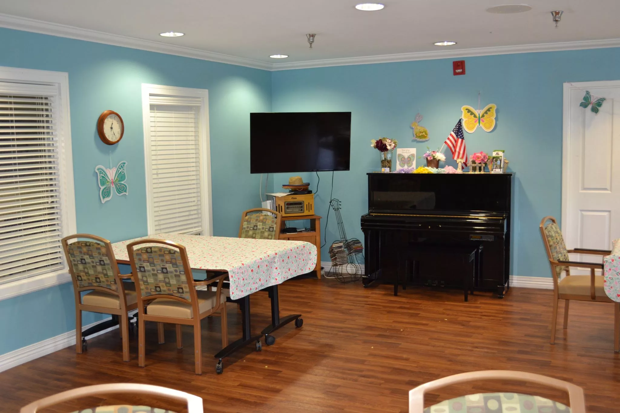 A cozy room with a piano, television, and decorated walls.