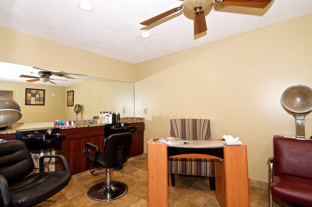 A well-organized salon interior with a hair styling and nail station.
