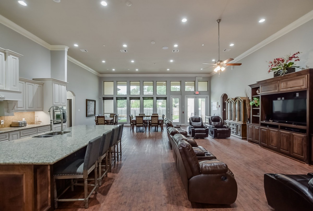 Spacious open-concept living and dining area with modern kitchen island and large windows.