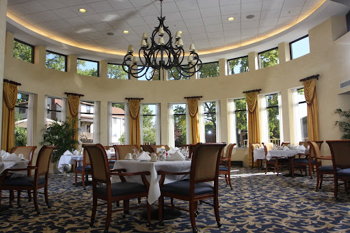 A beautifully designed dining room featuring elegant decor and ample natural light from large windows.