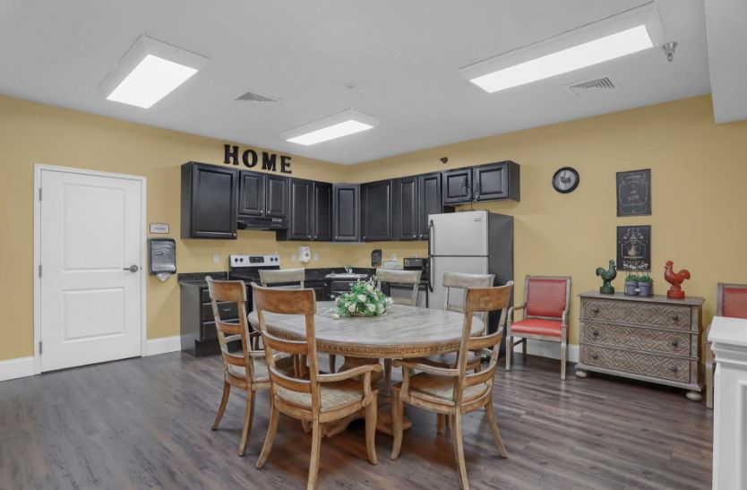 A cozy kitchen and dining area featuring black cabinets, a round table with chairs, and modern appliances.