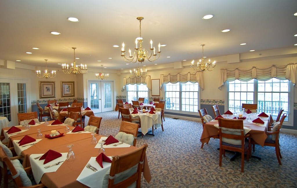 Elegant dining room with chandeliers and neatly arranged tables.