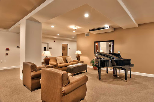 A cozy living room featuring a grand piano and comfortable seating, perfect for gatherings and music.