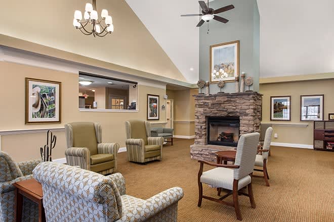 A cozy living room with a stone fireplace and various seating arrangements.