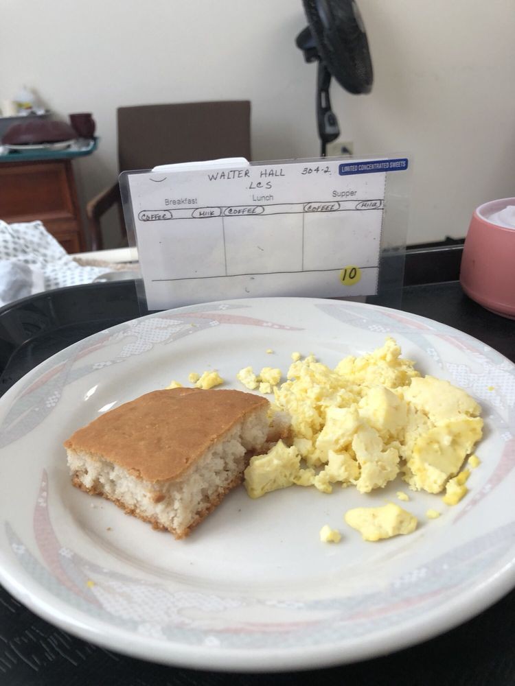 A breakfast meal consisting of scrambled eggs and a pancake on a plate.