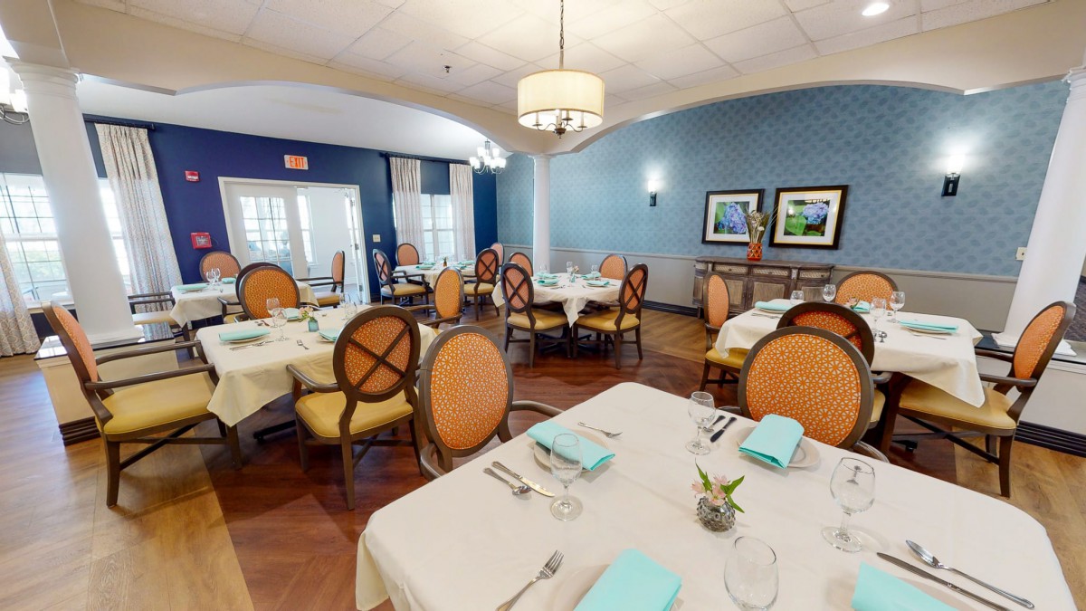 A well-appointed dining room with elegantly set tables and comfortable chairs, featuring tasteful decor and soft lighting.