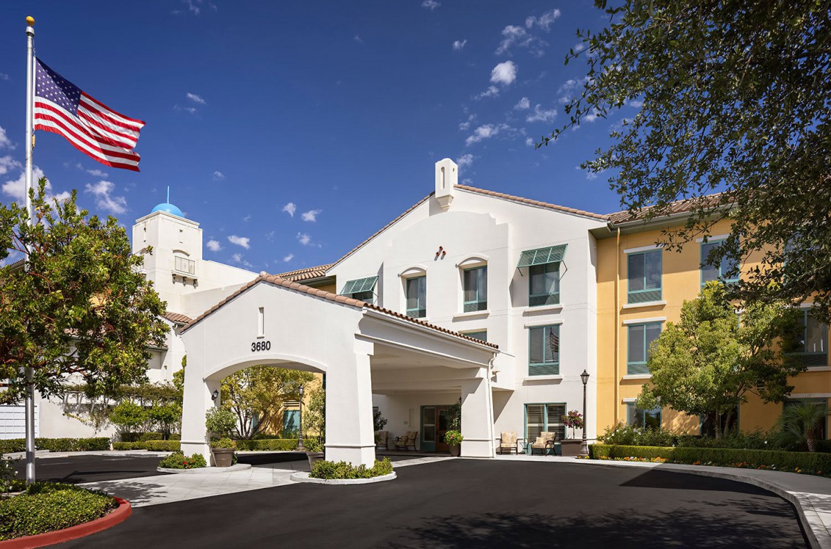 A modern hotel building under a clear blue sky.