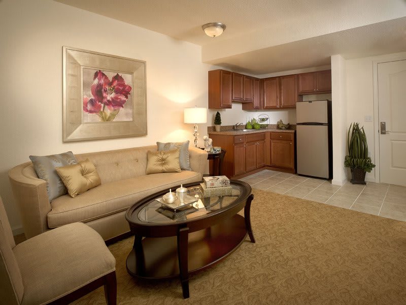 A cozy open-concept living room and kitchen space with warm lighting and modern furnishings.