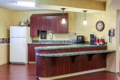 A modern kitchen featuring wooden cabinets, a granite countertop, and various appliances.