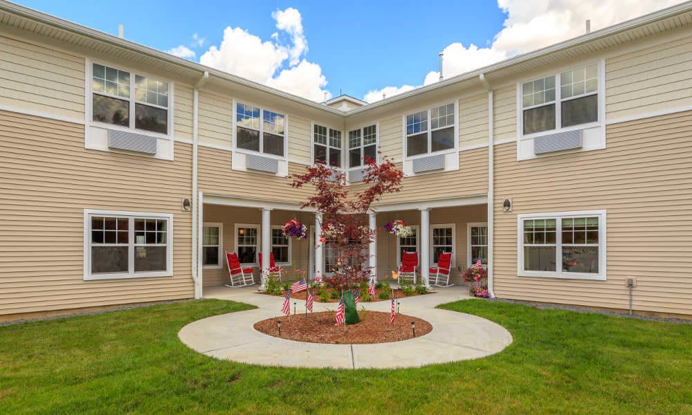 A residential building with a landscaped courtyard under a partly cloudy sky.