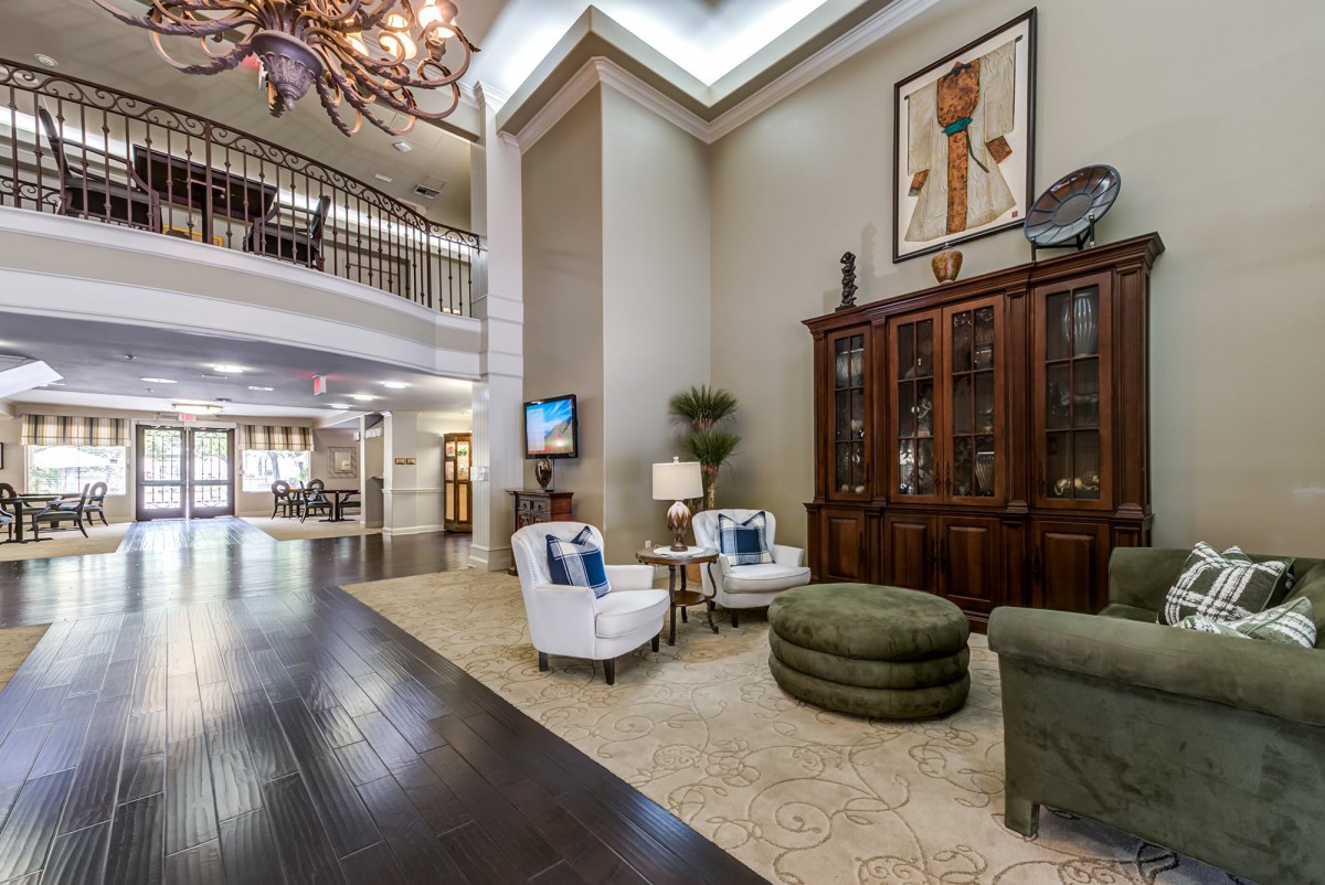 A spacious and elegantly decorated lobby with comfortable seating and a grand chandelier.